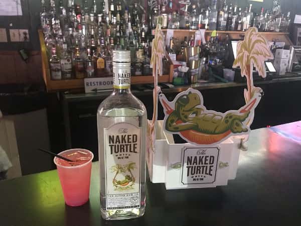 Naked turtle liquor bottle next to cocktail
