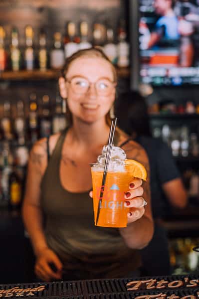 woman holding orange cocktail