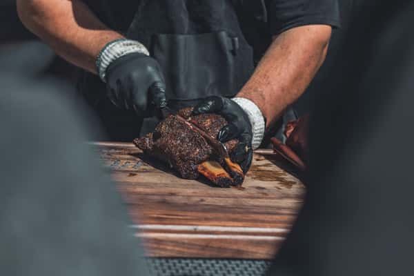A person cutting into a rack of ribs