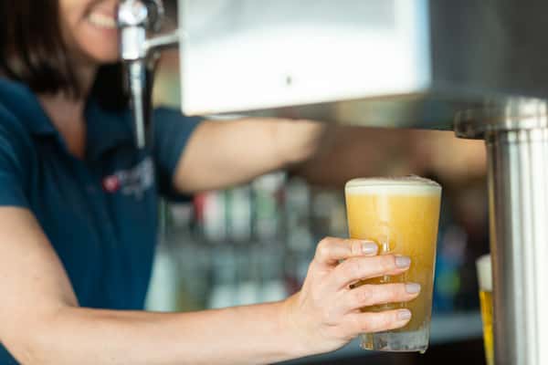server pouring glass of beer