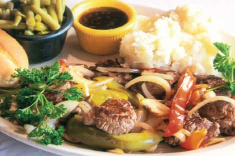 Grilled steak tips with grilled onions, peppers and mushrooms served with mushed potatoes, side green beans and a dipping sauce