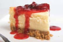 A piece of cheesecake with strawberry sauce