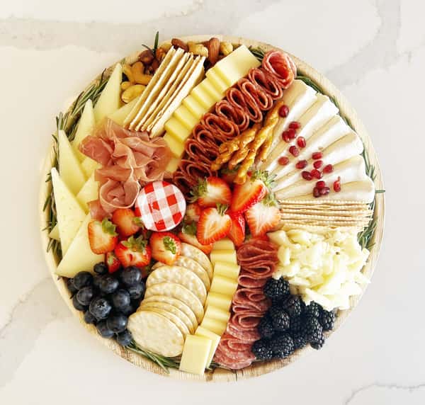 Curated selection of dried, cured Italian meats, artisanal cheeses, fruits, crackers and accoutrements