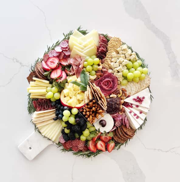 Curated selection of dried, cured Italian meats, artisanal cheeses, fruits, crackers and accoutrements