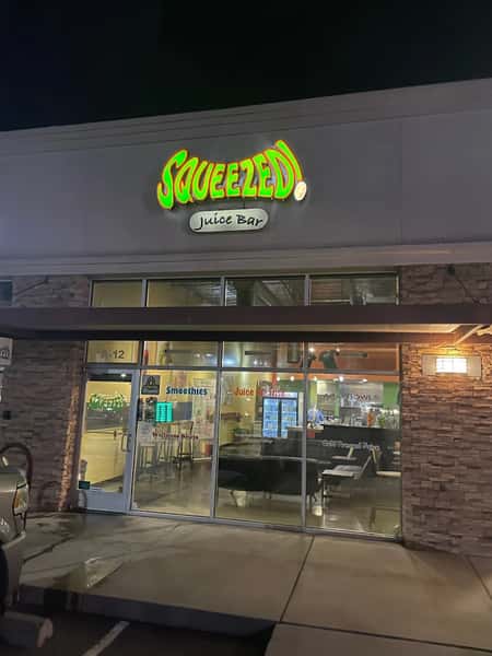 Squeezed Juice Bar storefront with signage and glass entrance in a modern shopping plaza, showcasing a clean and inviting exterior