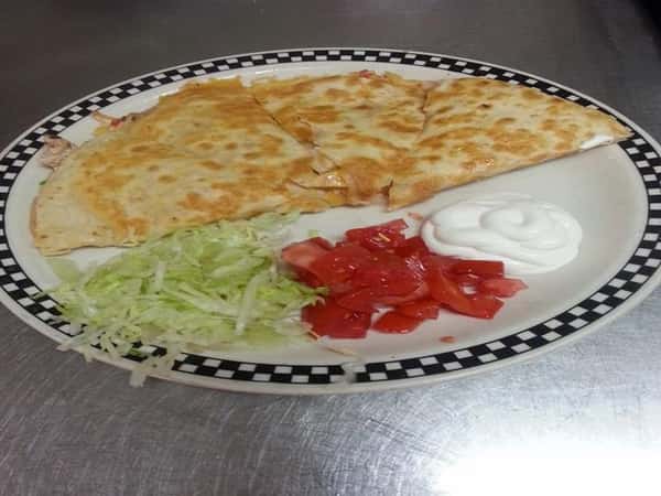 Quesadilla with a side of lettuce, tomatoes, and sour cream