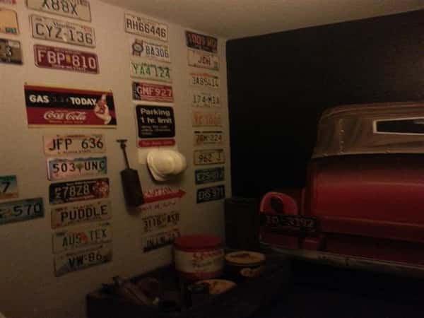 Wall filled with license plates, hats, and tools