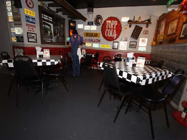 Checkered pattern dining area with walls filled with vintage decorations