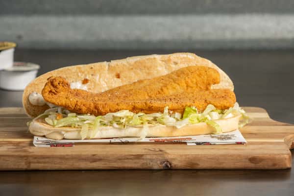 Texas Tom's crispy fish fillet sandwich with lettuce on a toasted sesame seed bun