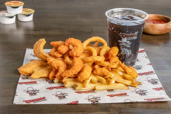 Texas Tom's crispy seafood basket with fried seafood, onion rings, fries, and a soft drink
