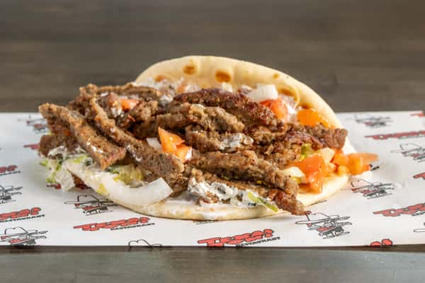 Texas Tom's gyro with seasoned meat, fresh tomatoes, onions, and creamy sauce in warm pita bread