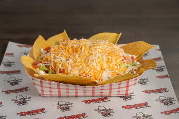 Texas Tom's taco salad loaded with seasoned meat, lettuce, tomatoes, shredded cheese, and tortilla chips