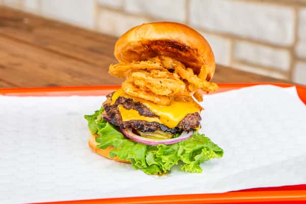 Double cheeseburger stacked with crispy onion rings at Jimmy's Burgers & Pizza in Hurst, TX