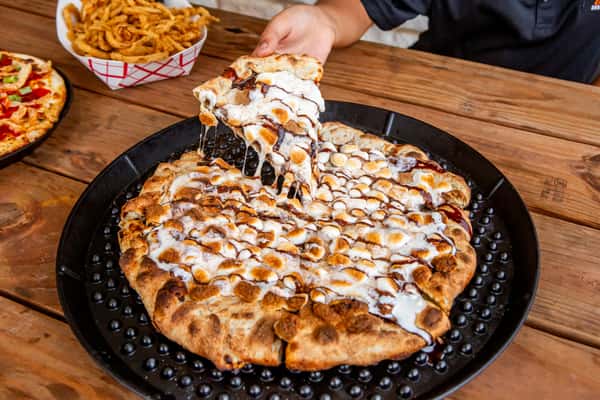 Freshly prepared pizza drizzled with sauce at Jimmy's Burgers & Pizza in Hurst, TX