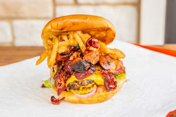 Cowboy burger loaded with bacon, cheese, and crispy onions at Jimmy's Burgers & Pizza