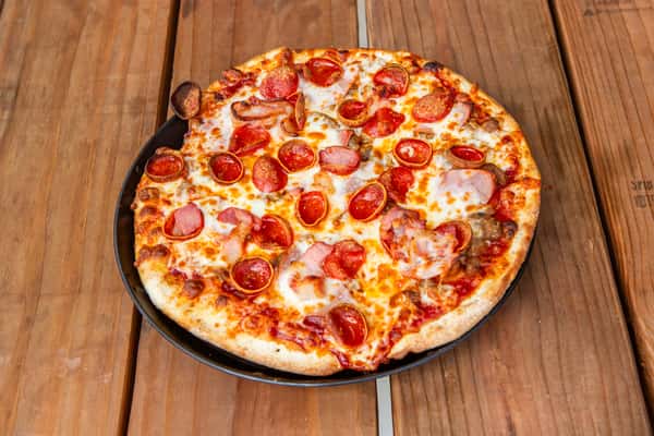 Meat lovers pizza topped with pepperoni and savory meats at Jimmy's Burgers & Pizza in Hurst, TX