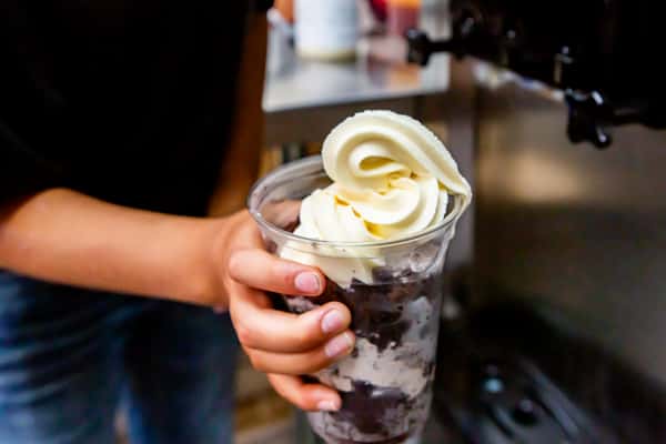 Soft serve dessert being prepared with chocolate sauce at Jimmy's Burgers & Pizza