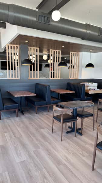 Dining area with navy booth seating and wood slat partitions
