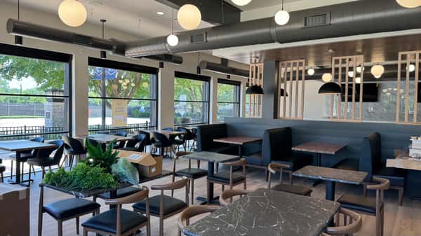 Dining area with pendant lighting, bar seating, and large windows