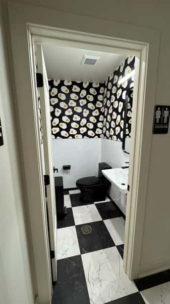 Restroom with polka dot wallpaper and black and white checkered floor