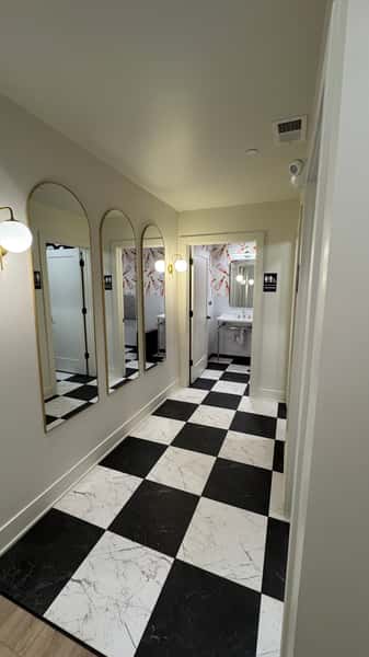 Hallway with arched mirrors and black and white checkered floor
