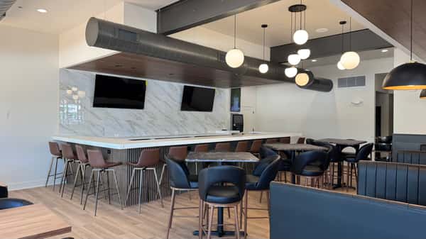 Dining area with globe pendant lighting, marble counter, and bar stools