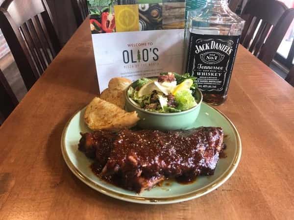 bbq plate with a side of house salad with a bottle of jack daniels whiskey