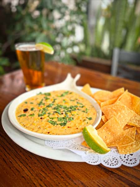 Saucy bowl with crispy sides and a drink