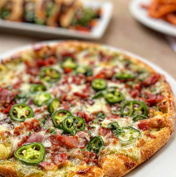 Cheese pizza topped with peppers and meat slices