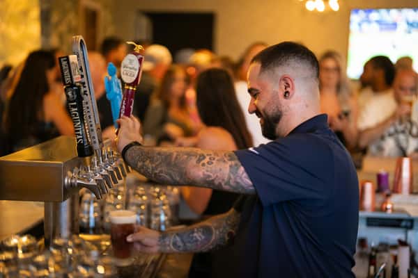 A bartender pouring beer from a tap