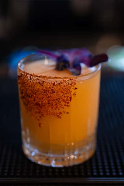 Cocktail with purple flower garnish
