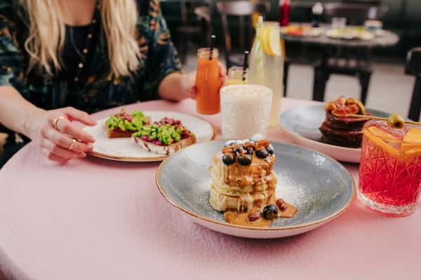 A woman sitting at a table with plates of food