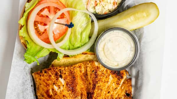 Blackened fish sandwich served with fresh lettuce, tomato, onion, pickle, and tartar sauce at Malabar Mo's Bar & Grill in Malabar, FL.