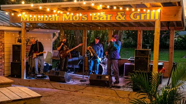 Outdoor stage with a live band performing at Malabar Mo's Bar & Grill in Malabar, FL during an evening of local music and entertainment.
