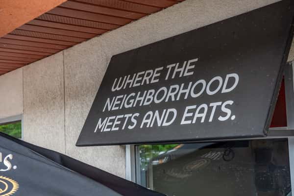 Where the neighborhood meets and eats sign