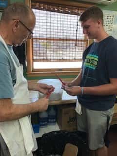 two male employees cutting up food