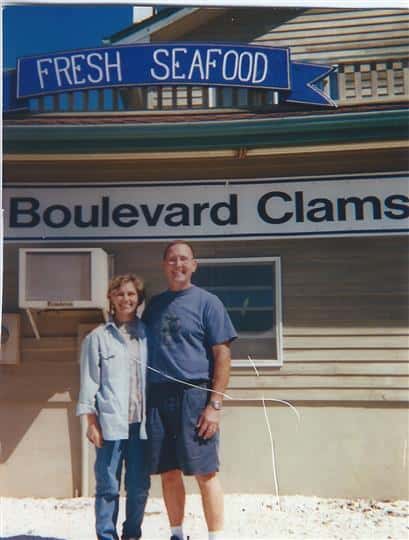 owners in front of boulevard clams sign