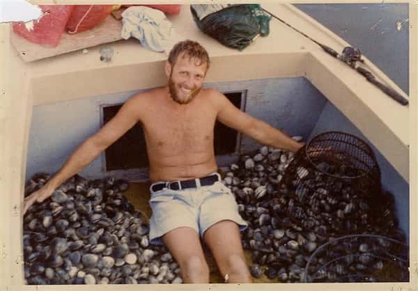 man on boat full of oysters
