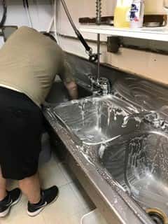 man cleaning sinks