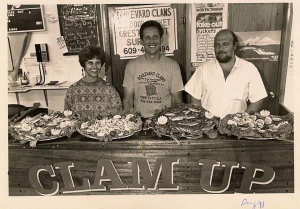 old photo of family owners behind the counter with seafood platters