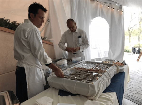 two employees preparing buffet table