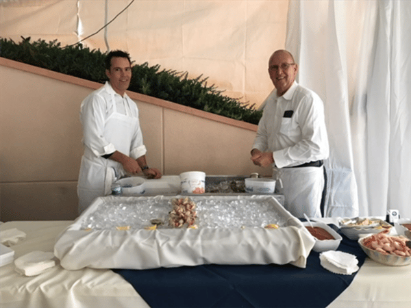 two employees standing behind buffet table