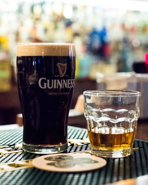 glass of guinness and glass of whiskey on bar