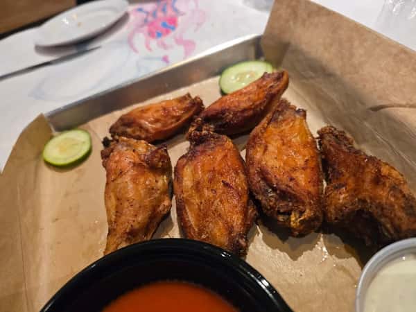 Crispy golden chicken wings served with tangy buffalo sauce, ranch dip, and cucumber slices — a classic game-day appetizer.