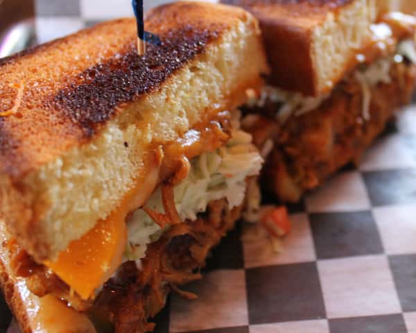 House-pulled pork tossed in your choice of sauce, topped with pickled jalapeños, cheddar cheese, habanero jack cheese, and coleslaw, sandwiched between a thick-cut brioche bun.
