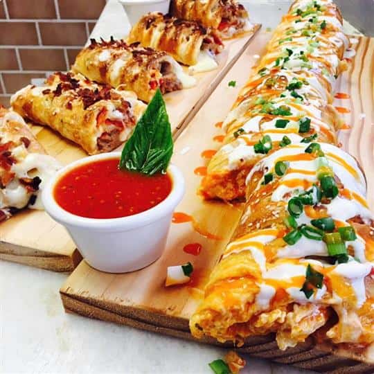 stuffed calzones with sauce on wooden boards