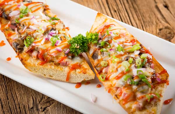 Cheesy bread layered in a sauce and topped with a garnish