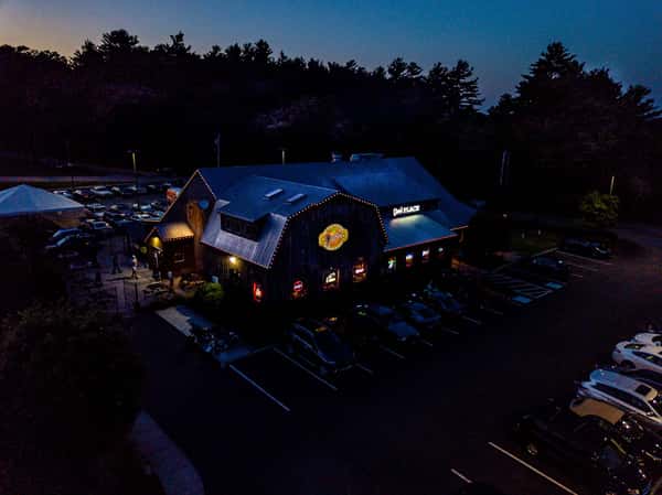nighttime restaurant exterior with glowing lights and outdoor seating creating a lively evening atmosphere