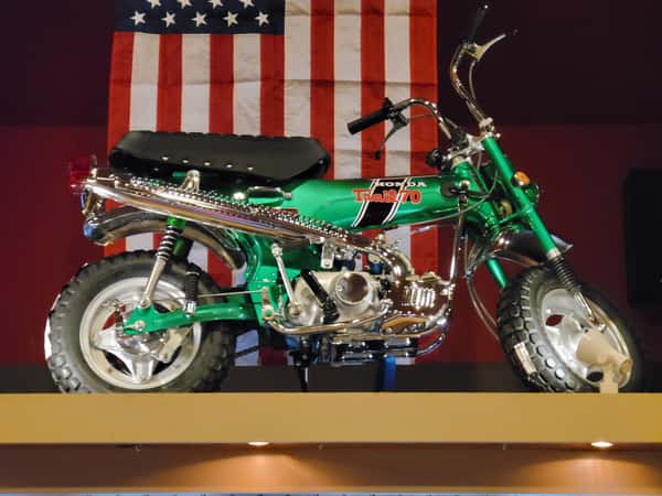 custom motorcycle displayed indoors with patriotic American flag backdrop and decorative lighting