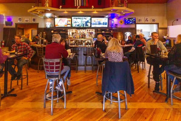 busy restaurant dining room with guests seated at tables in a warm, casual atmosphere
